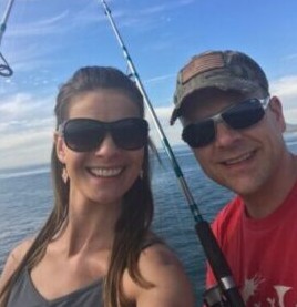 Sara and Scott with fishing poles and the ocean behind them